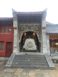 Brightly painted Buddhist temple threshold with red and gold lanterns, symbolizing sacred boundaries and spiritual entry.